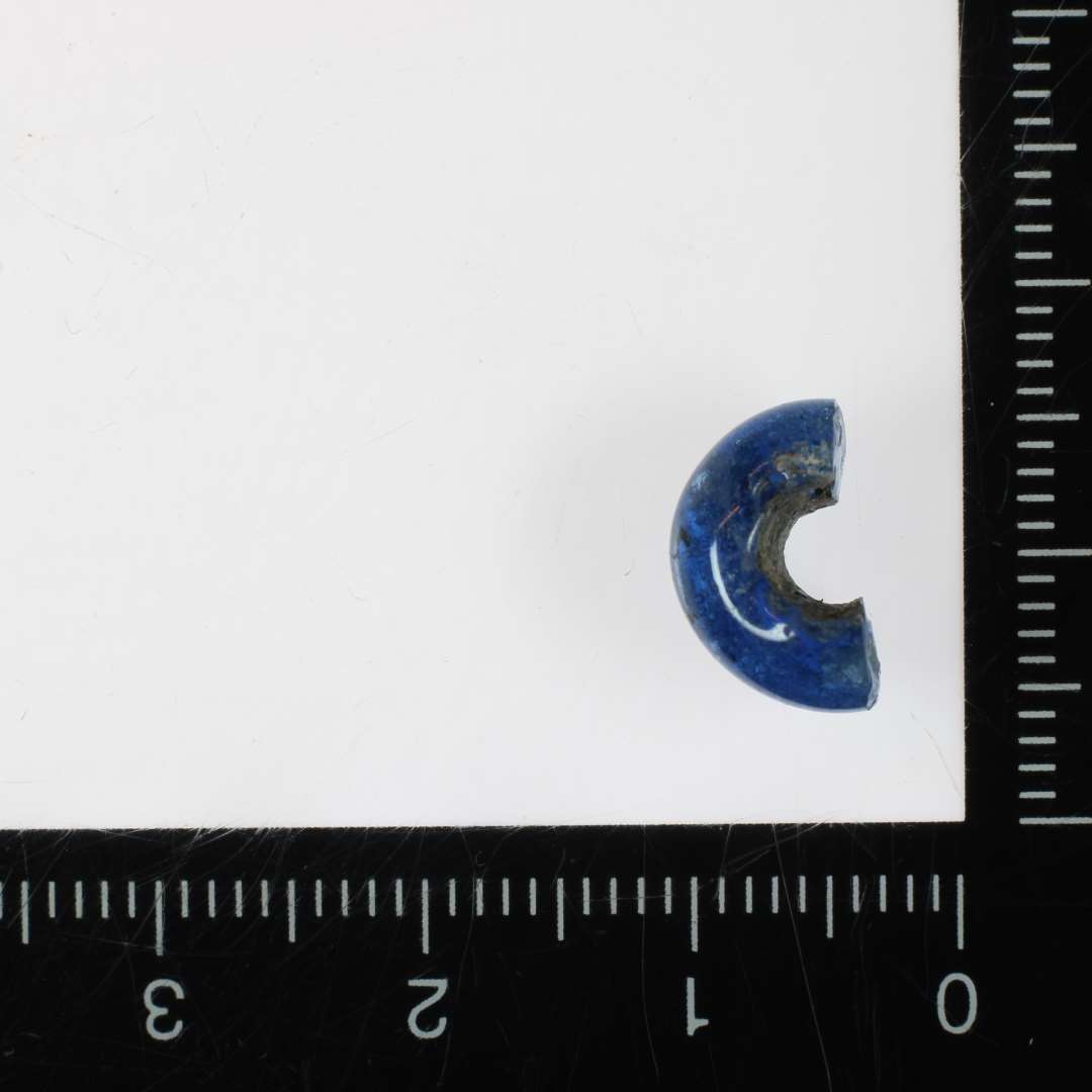 ½ perle af afrundet ringform af blå gennemsigtig glas. 11 mm.