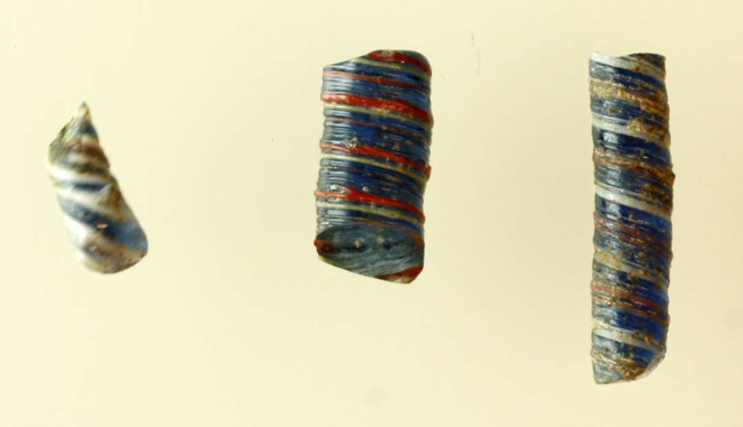 3 fragmenter af tovsnoede glasstænger af varierende tykkelse af blåligt gennemsigtigt glas omviklet med tynde tråde af ugennemsigtig hvid og rødbrunlig glasmasse i S-snoet forløb.