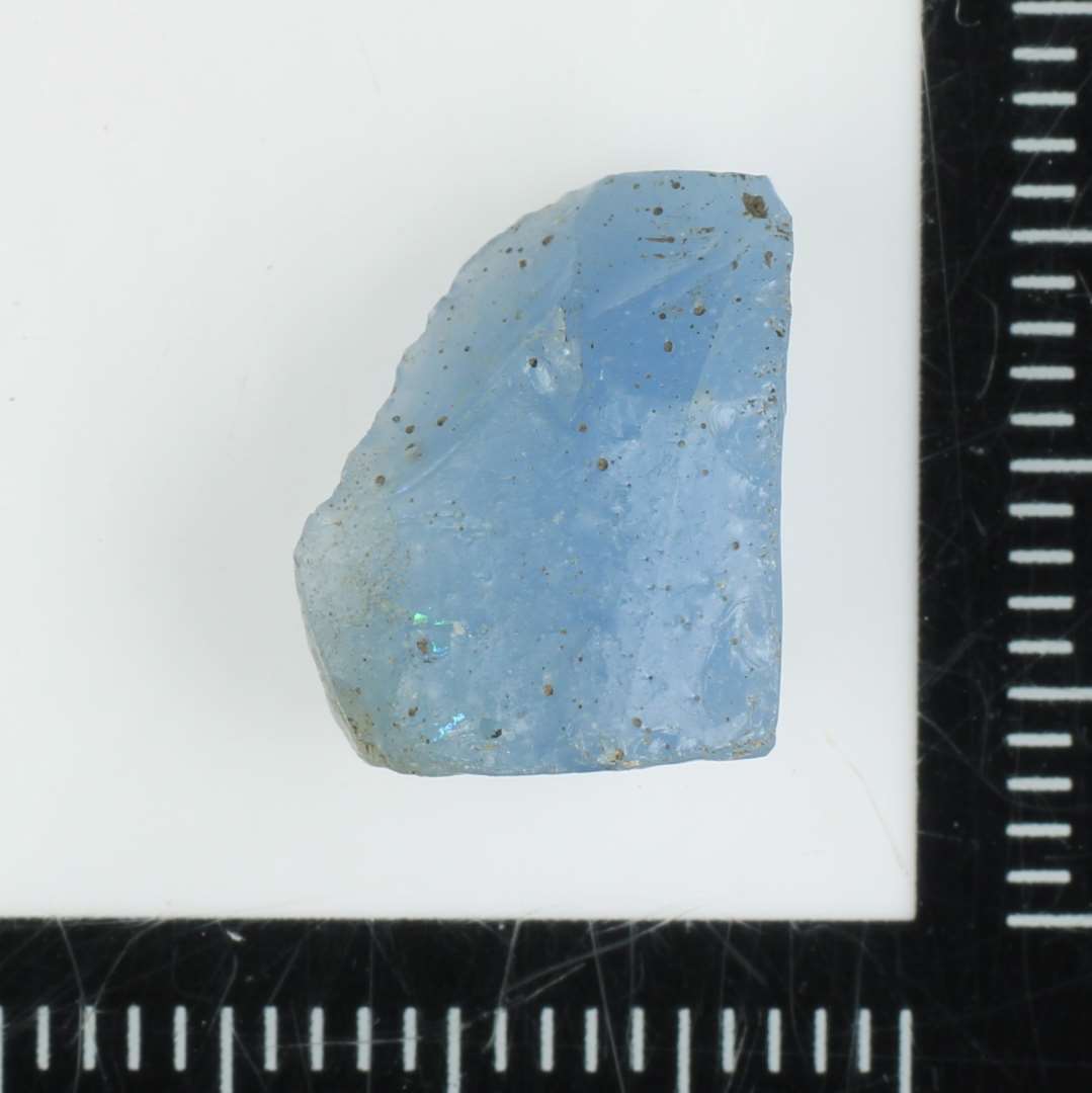 1 stykke råglas eller mosaikstiftfragment af svagt blålig, ugennemsigtig glasmasse.