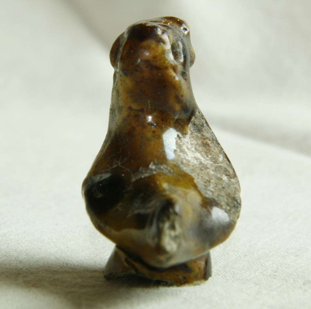 Figur af glaseret pibeler, forestillende en and. Fra neden et hul op i figuren, til pind eller lignende. 5x3,5 cm. Marionet. Legetøj.