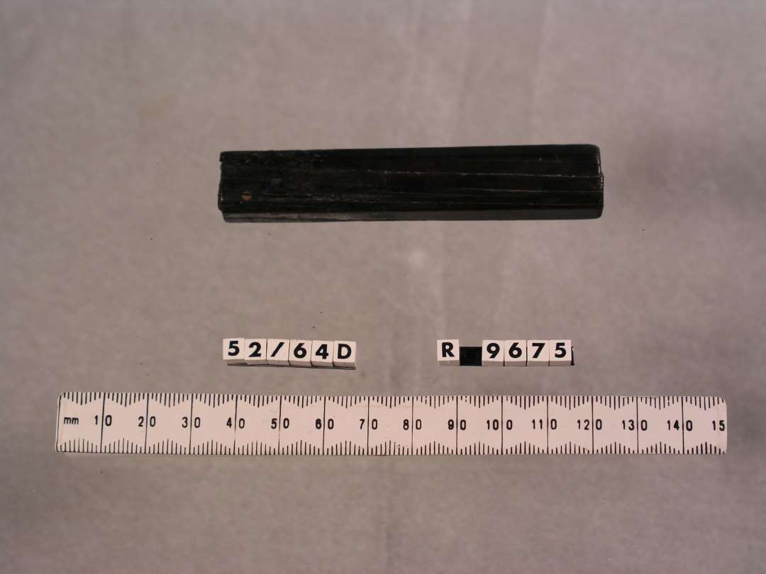 Håndtag af horn. Firsidet, med jern bevaret indeni fra det redkab der har været fastgjort i håndtaget. Længde: 8,5 cm., tværsnit: 1,2x1,5 cm.