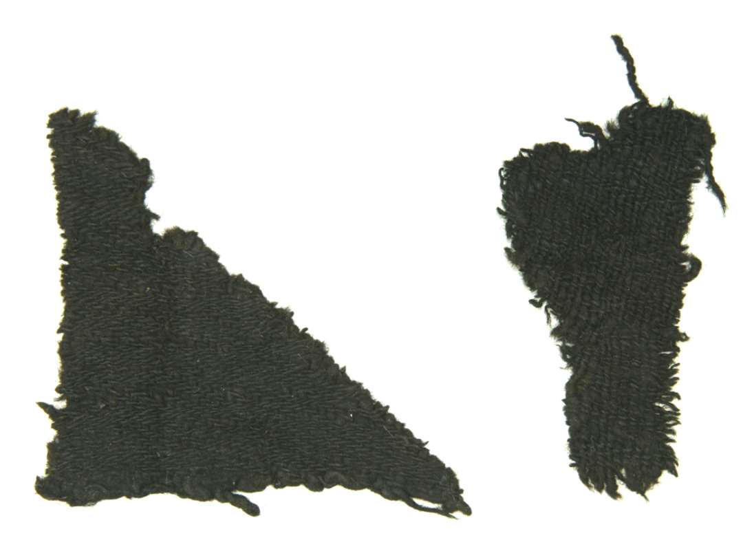 To stykker tekstil. Mål h.h.v.:14x9,5 og10x9,5 cm. 