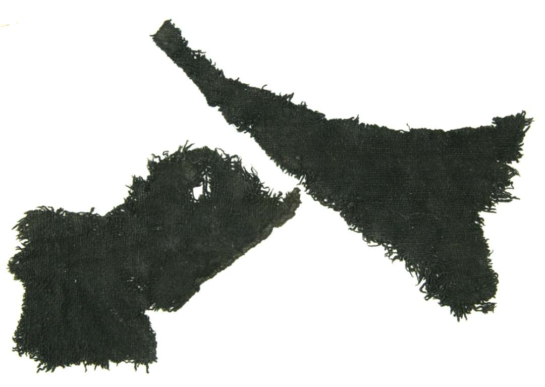 To stykker tekstil. Mål h.h.v.: 10,5x22 og 16,5x10 cm.