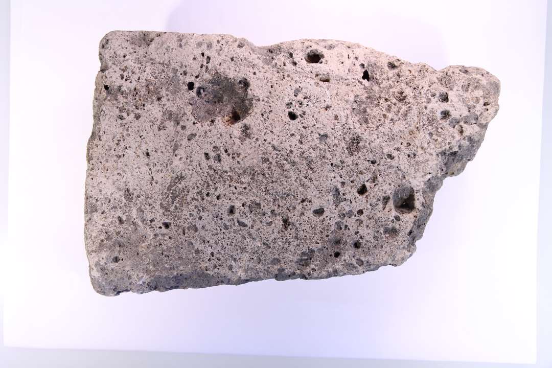 Fragment af gråhvid tufsten. 28,5x18x9.5 cm.