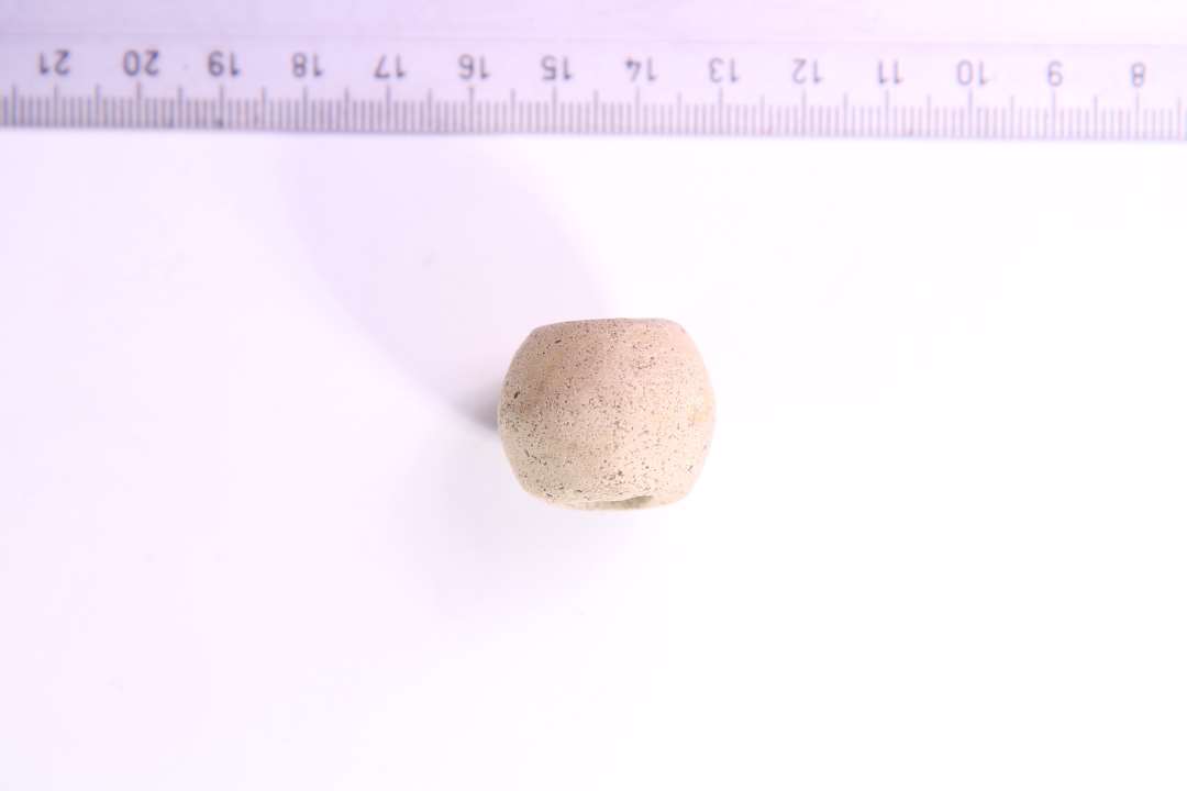 Gullighvidt, fint magret ler. H: 2.1 cm. Største diameter: 2.5 cm. Hullets diameter: ca. 0.8 cm.