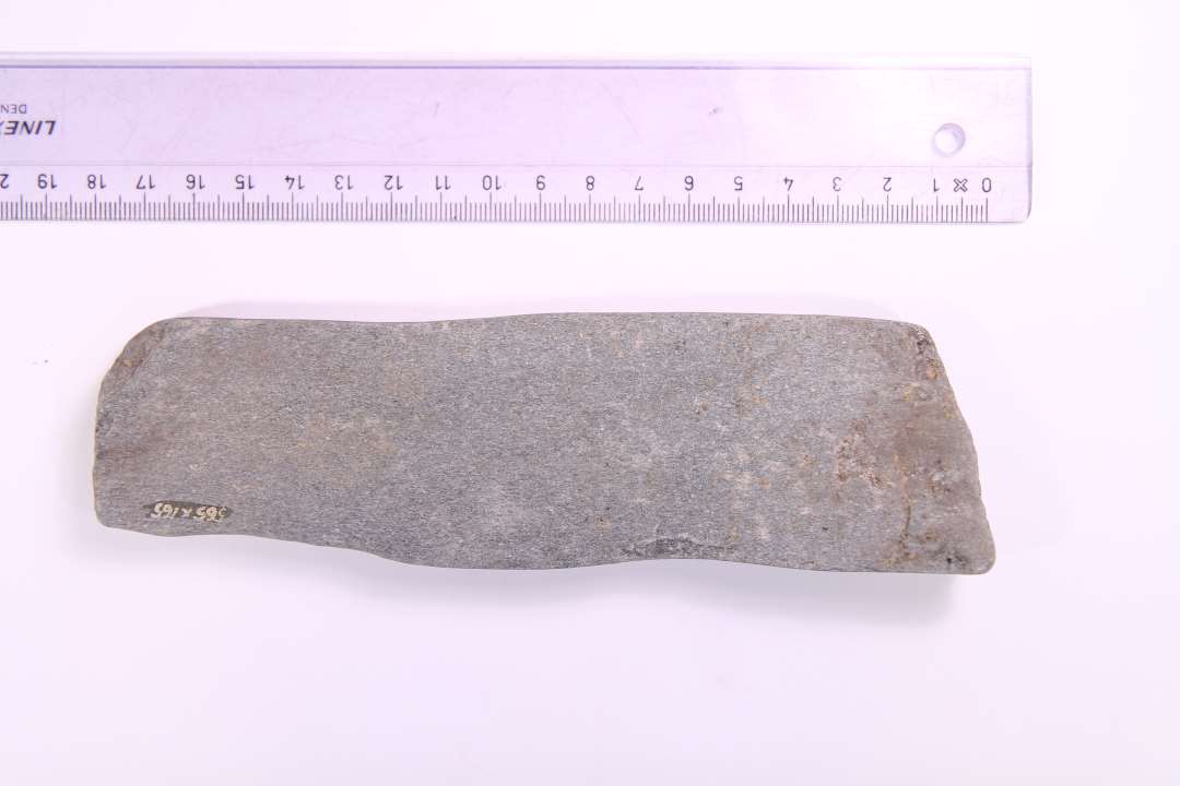 Fragment af stor, bred og flad hvæssesten. Største mål: 17,5 cm.