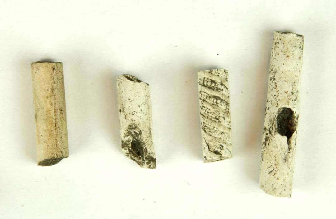 4 fragmenter af kridtpibestilke, heraf den ene med ornamenter. 