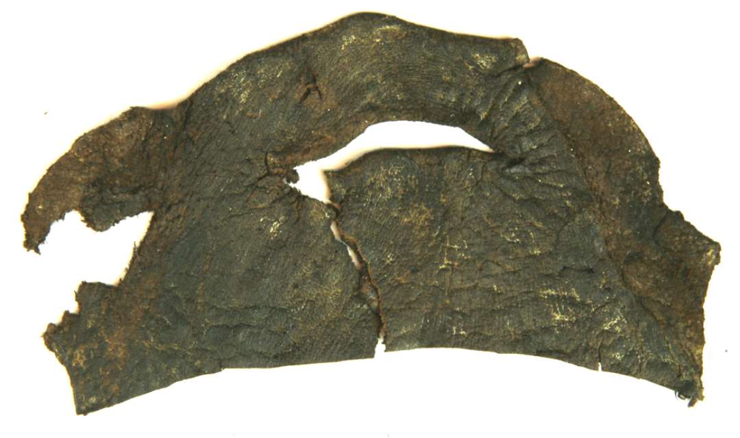 1 stk. forskåret læder af uregelmæssig form ca. 6 x 12 cm. med en indskåret snørelidse ca. 3,5 cm. lang.