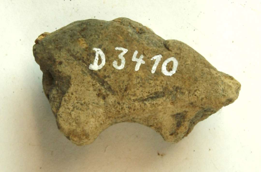 1 fragment af discosformet vævevægt af gråbrunlig, brændt lermasse. Største mål: 5,5 cm.