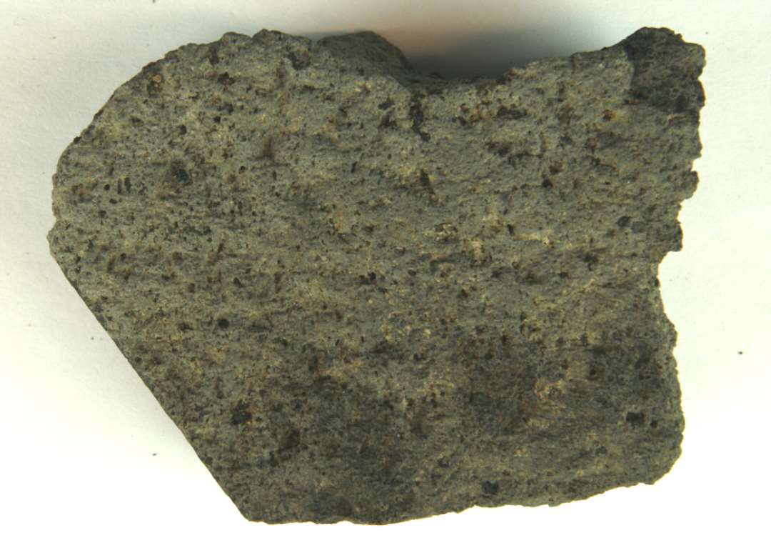 1 fragment af kværnsten af basaltlava. Med 2 afglattede sider.