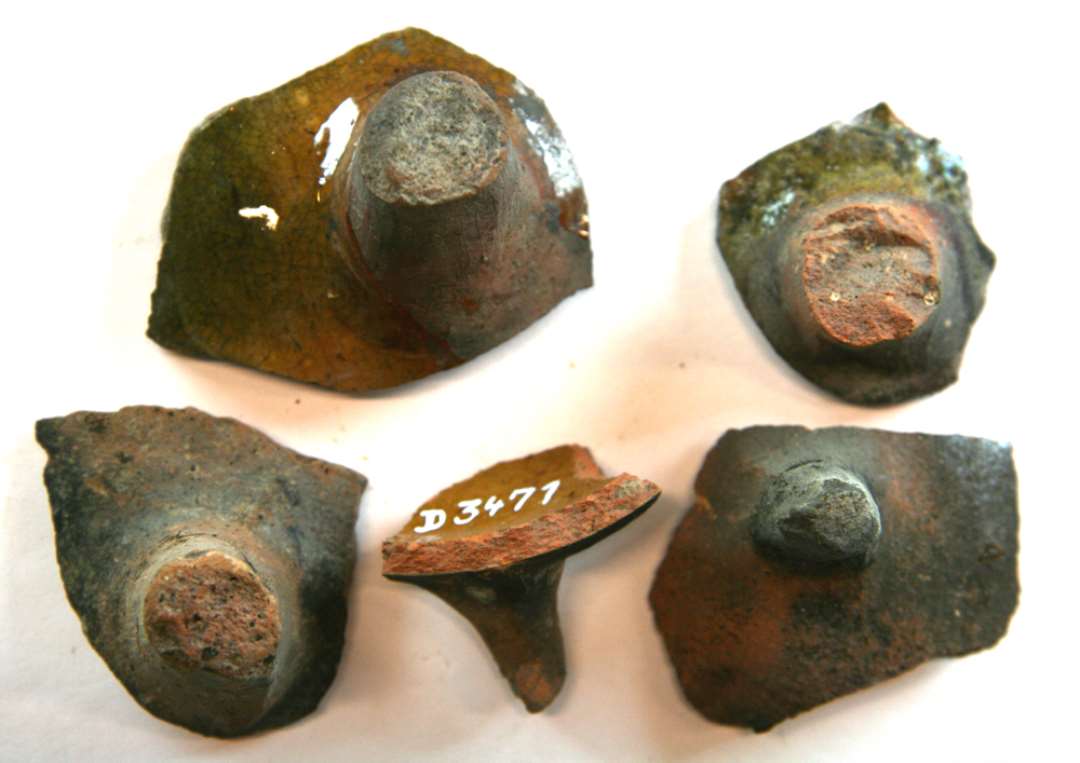 5 stjertpottetæer fra potter af rødbrændt lergods med klar eller grønlig blyglasur på indersiden, gruppe 1.