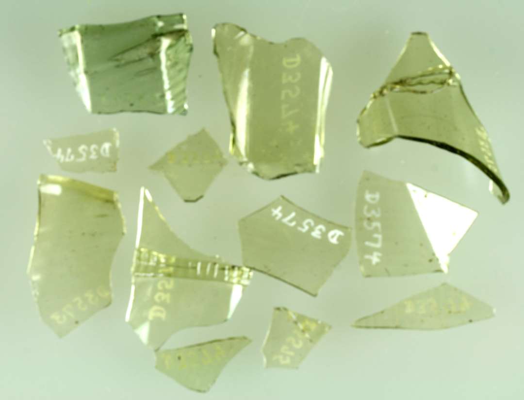 3 sideskår af gennemsigtigt svagt grønligt glas fra såkaldte stangenglas med svag skrårifling i vægsiden og pålagte tandede rigler på ydersiden  ( pasmærker ). D3573, D3574, D3575 sammenhørende.