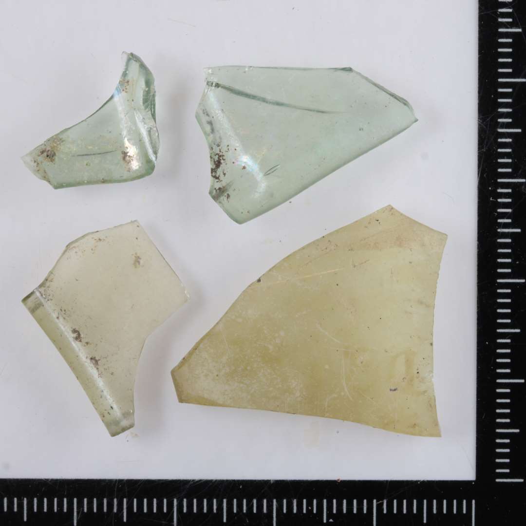 4 randskår af gennemsigtigt grønligt glas med glat let fortykket munding fra stangenglas af ottekantet form.