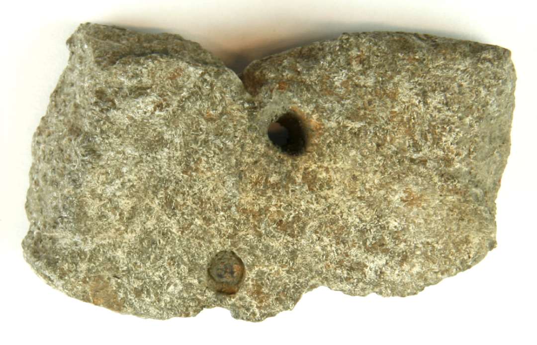 1 mundingsrandfragment af stenkar af større kar med indadbøjet rand. Der ses 2 klinkehuller, hvoraf det ene på begyndt ( ? ) i vægsiden. Karvægtykkelsen 1,5 - 1,6 cm. ( granit )
