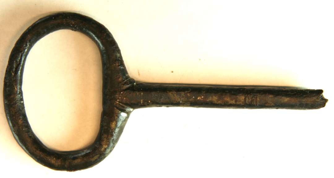 Fragmenteret jernnøgle med ovalt ornameteret greb og med afbrudt kam. L : ca. 12,1 cm. Grebets bredde ca. 6 cm.