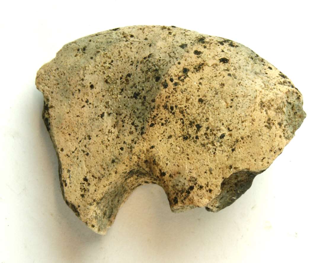 1 fragment af discoformet vævevægt af brændt lermasse med gråsort kærne og lysbrunlig overflade. Største mål: 7,5 cm.