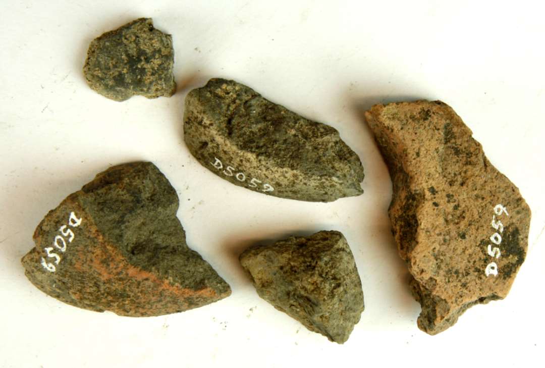5 fragmenter af discoformede vævevægte af gråbrunlig lermasse. Største mål: 2,5-6 cm.