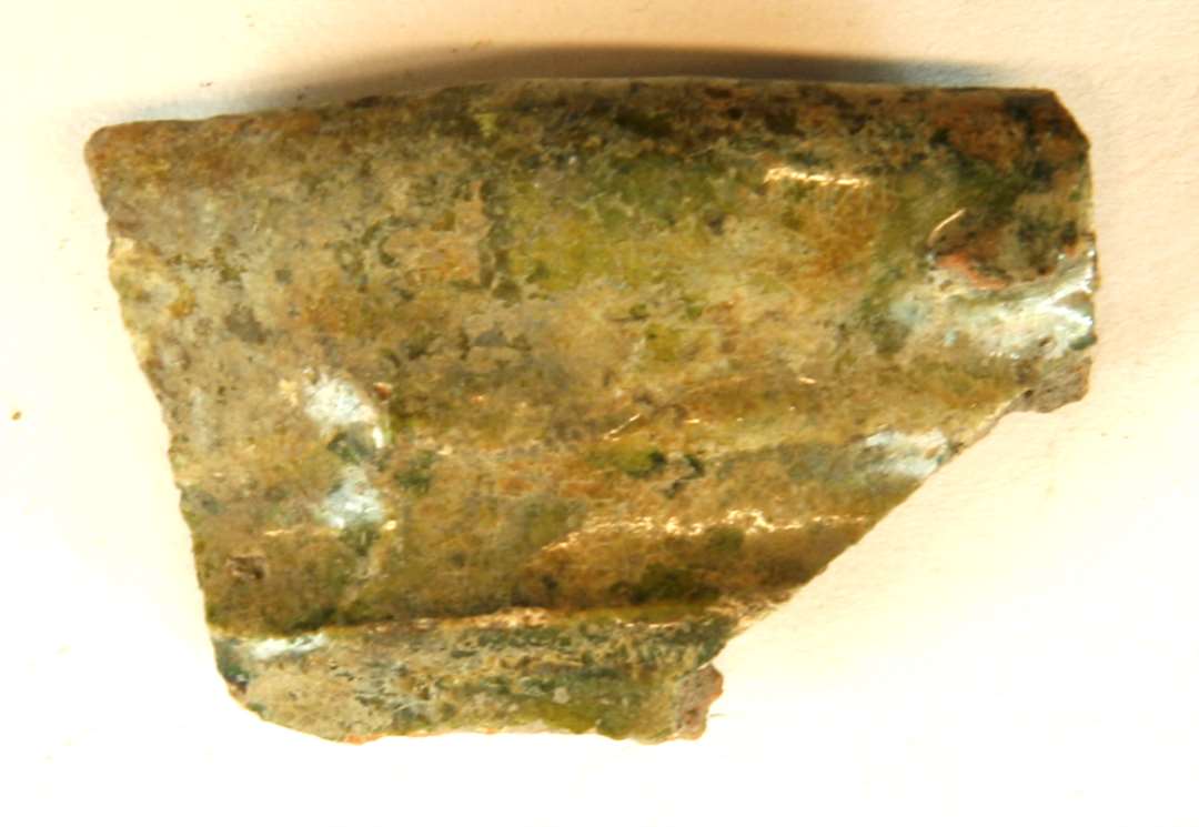 1 randskår af magret, rødbrændt lergods fra kande med klar blyglasur på såvel inder- som ydersiden, således at den fremtræder grøn, gruppe 1.
