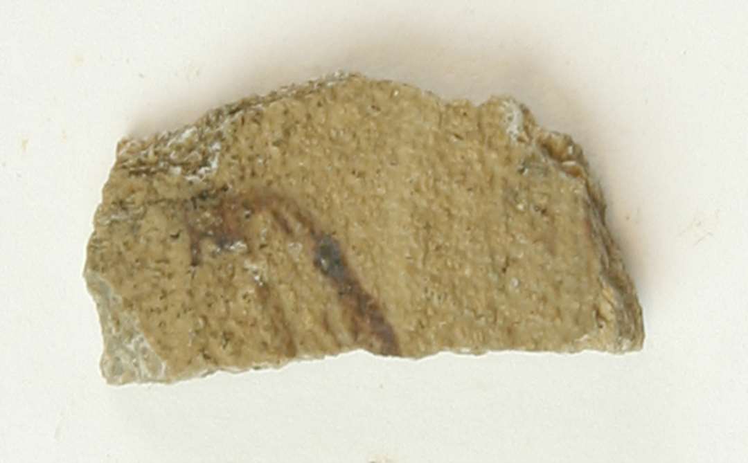 1 skulderskår af brungråt, finmagret porøst lergods med spor af brunlilla manganbemaling på ydersiden, pingsdorfvare, gruppe 10.