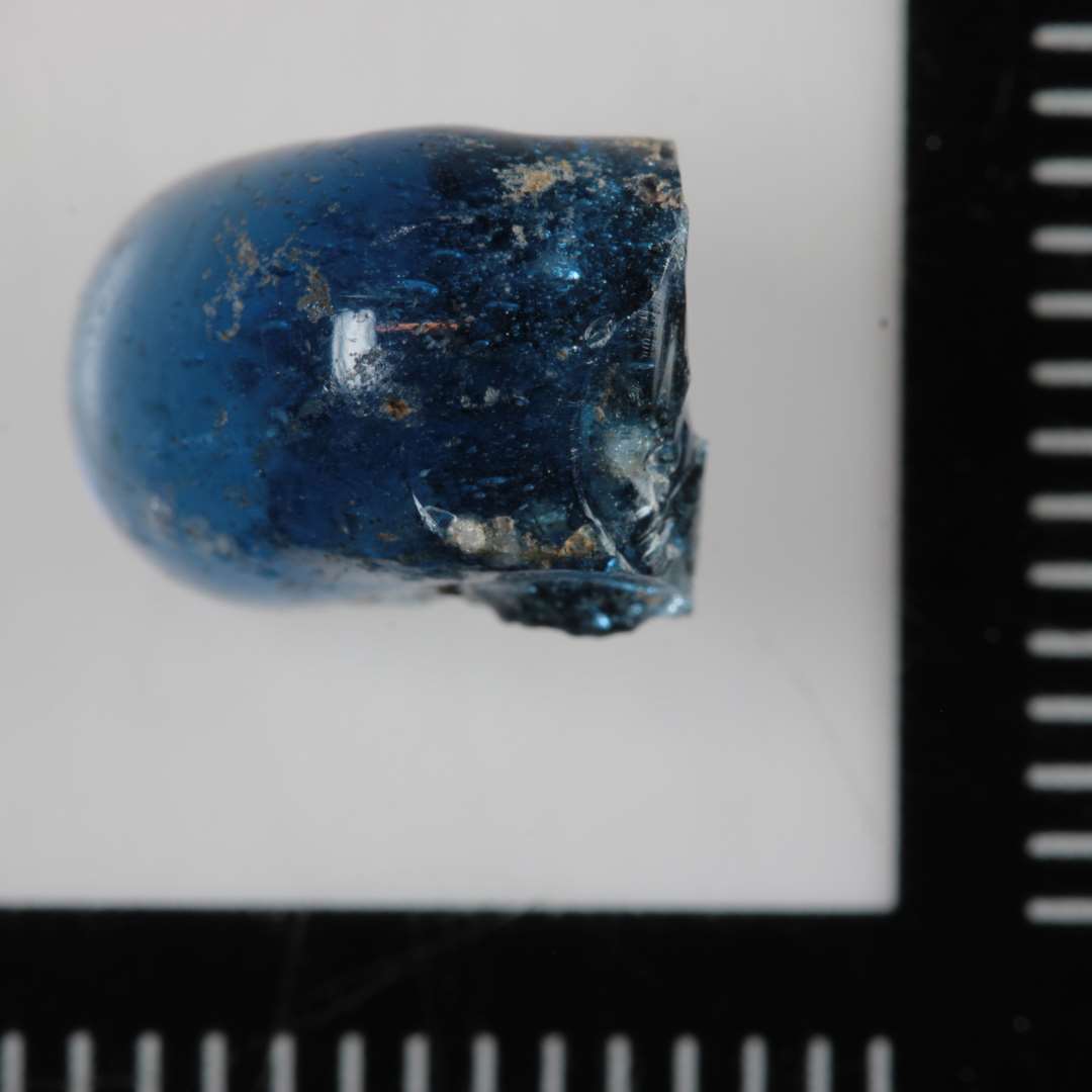 1 fragment af ringformet glasperle. Blåt, gennemskinneligt glas.