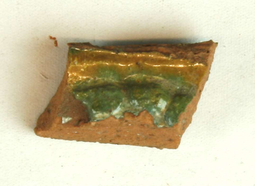 Fragment af polykrom kakkel. Største mål: 2,3 cm.