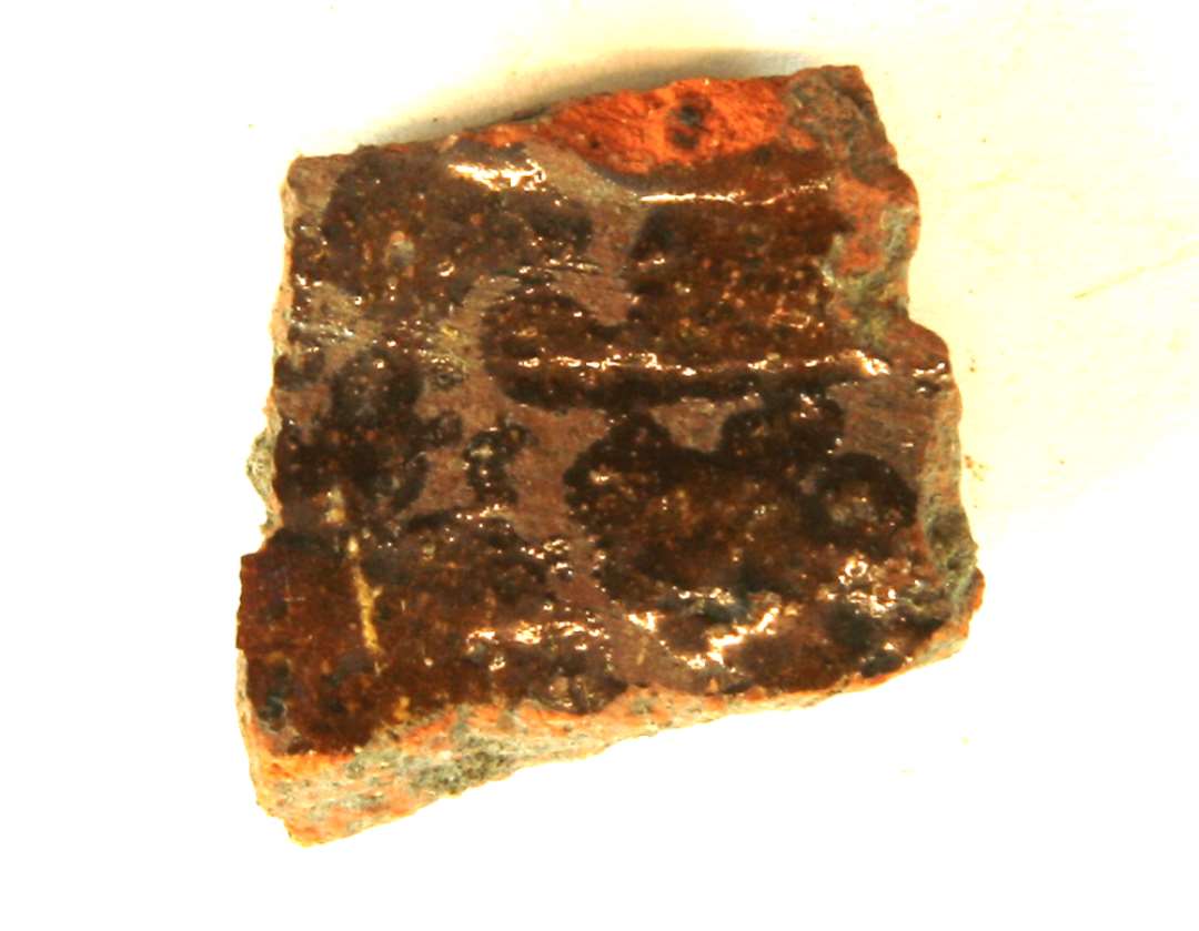  1 sideskår af rødbrændt gods med brunlig blyglasur på ydersiden, gruppe 1.