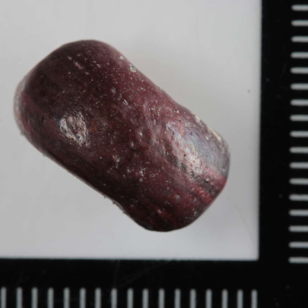 1 fragment af ringformet glasperle, brunt uigennemsigtigt glas.