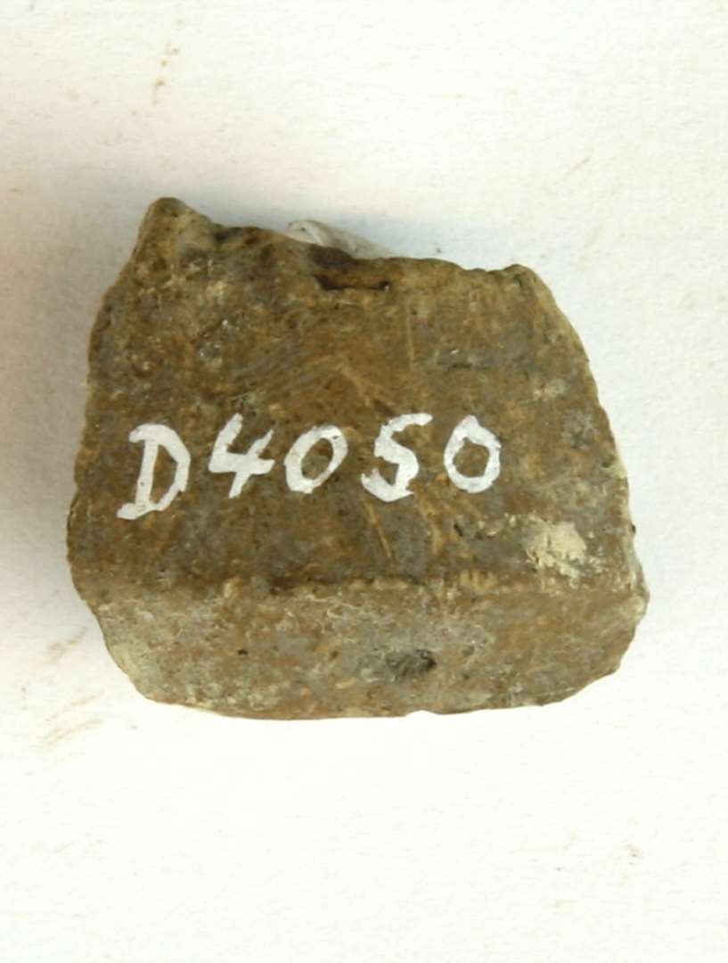 1 fragment af tenvægt af gulbrunlig lermasse. Fragmentet antyder en konisk form med affaset fod. Største mål: 2,5 cm.