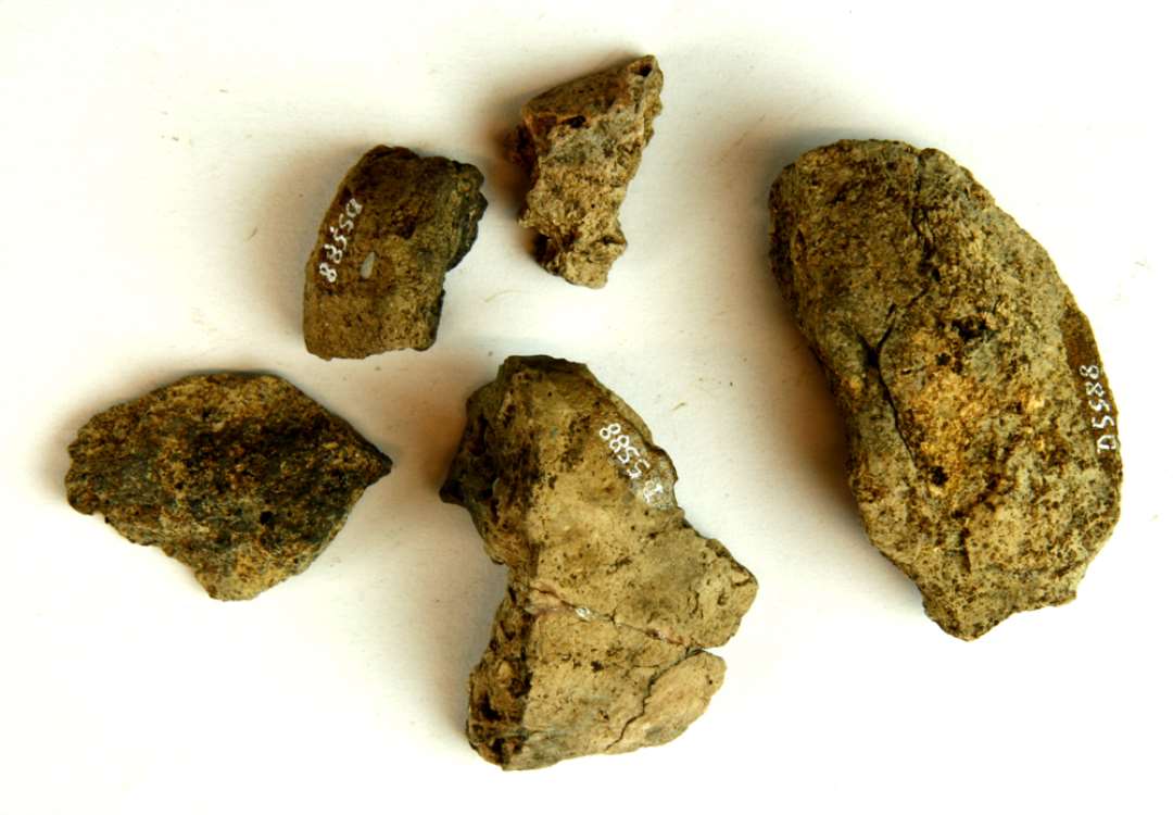 5 fragmenter af gulbrunlig lermasse, antagelig fra vævevægte. Største mål: 3-6 cm.