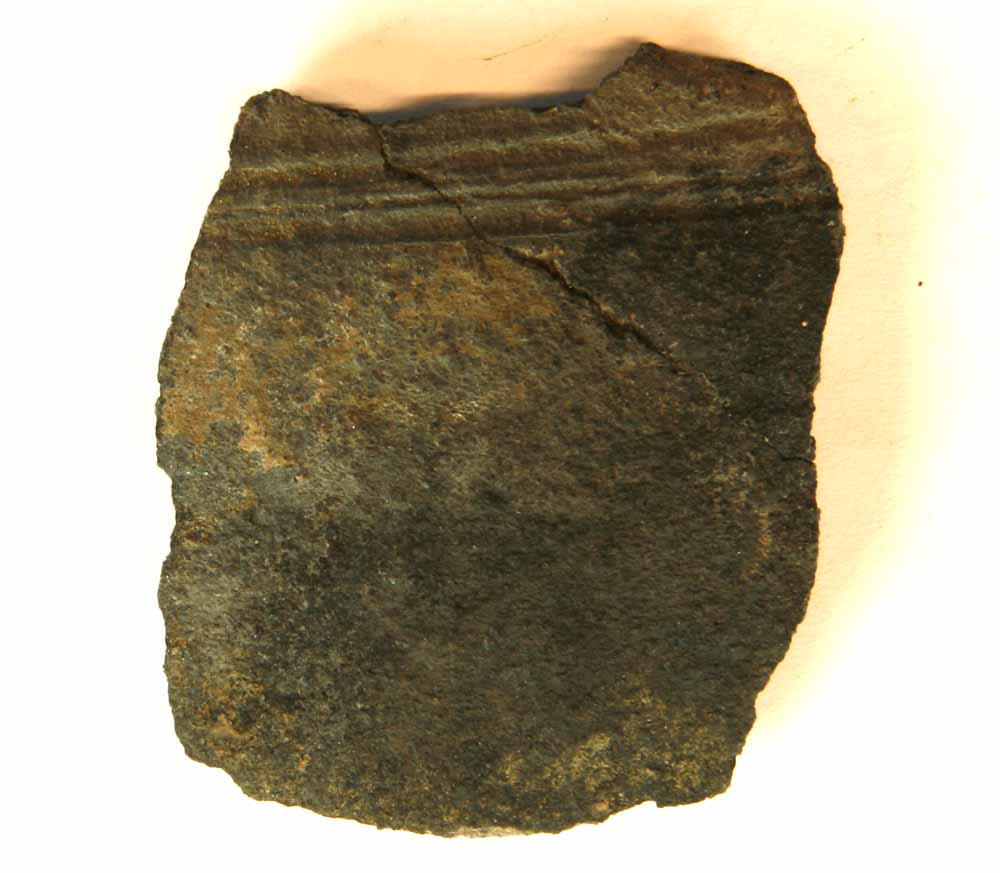 1 skulderskår af gråbrændt magret lergods fra kar med vandrette omkringløbende furer øverst på skulderen, gruppe 5.