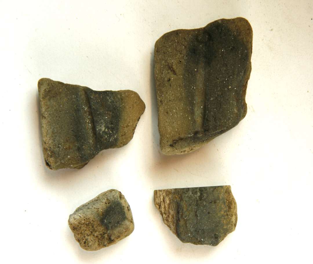 4 fragmenter af støbeformshalvdel af finmagret, kvartsblandet, gråbrunligt lergods med et støbefordybning til tynd aflang genstand. Mål: 2,3-4,5 cm.