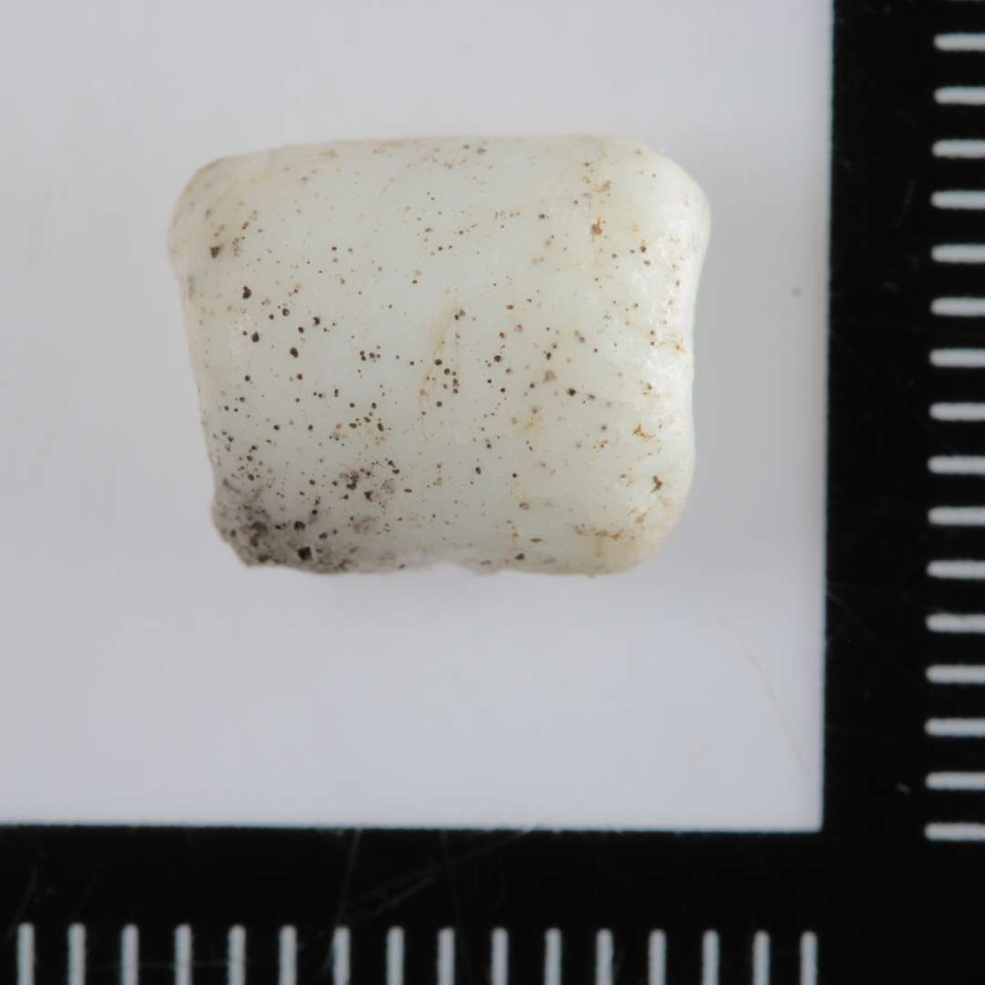 1 fragment af en cylinderformet perle af hvidt, opakt glas.