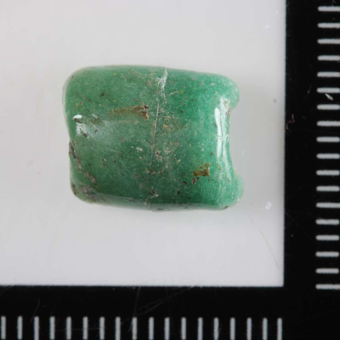 1 fragment af en cylinderformet perle af opakt, grønt glas.
