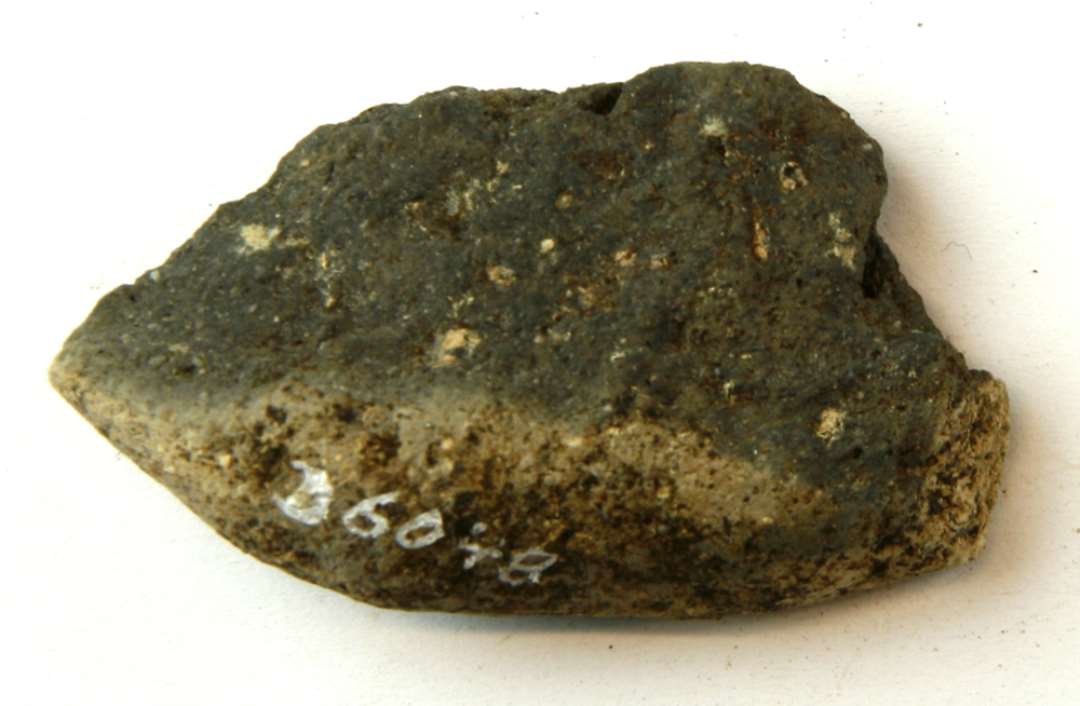 1 fragment af en vævevægt af brændt ler. Største mål: 6 cm.