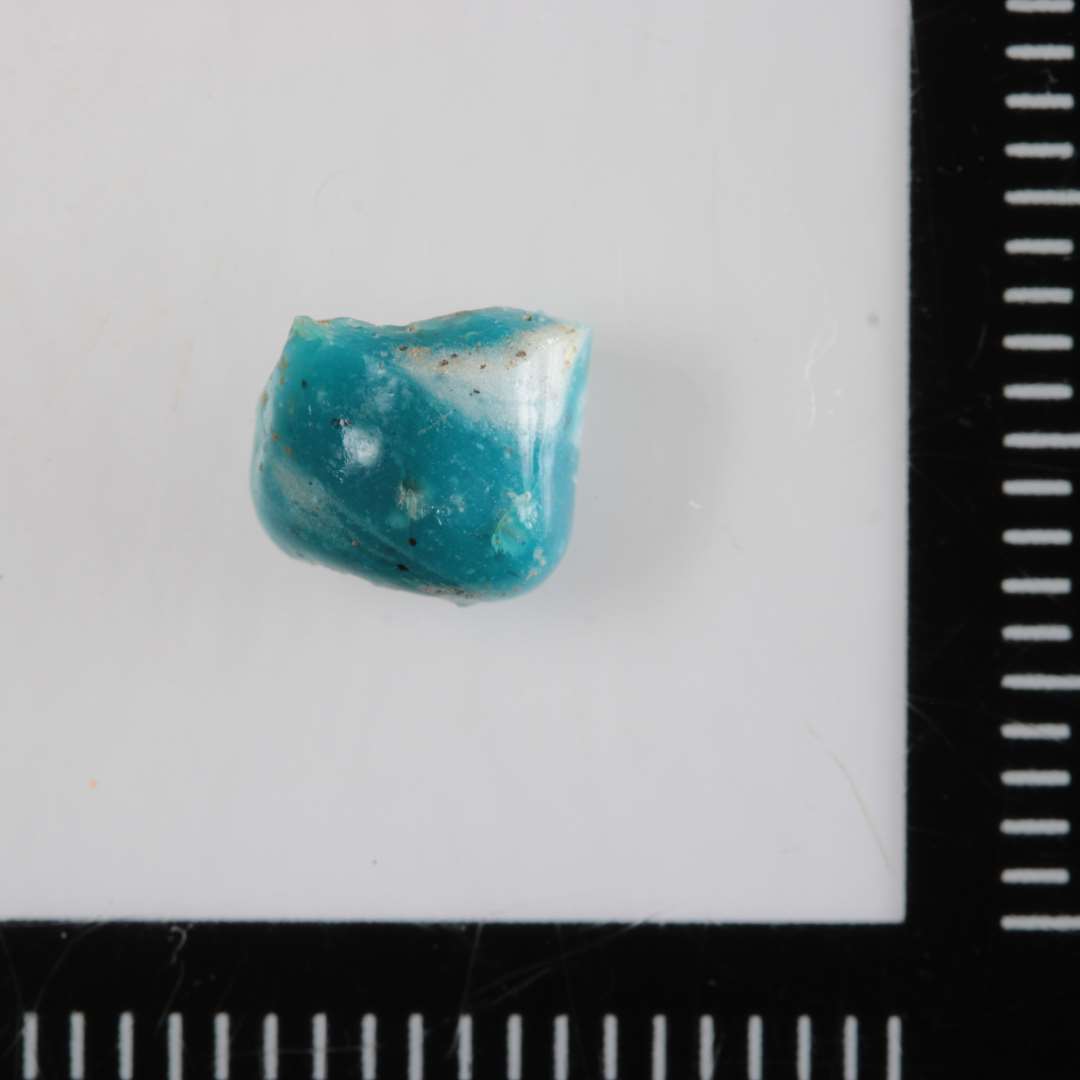 1 fragment af en cylinderformet perle af opakt, grønt og hvidt glas.