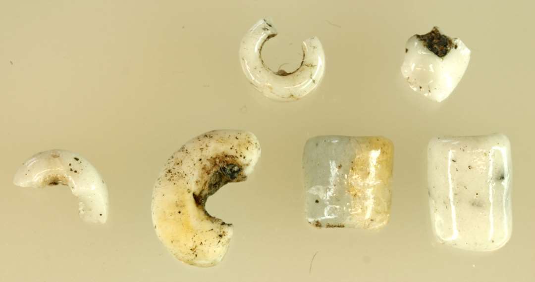 9 fragmenter af opakt hvide glasperler.