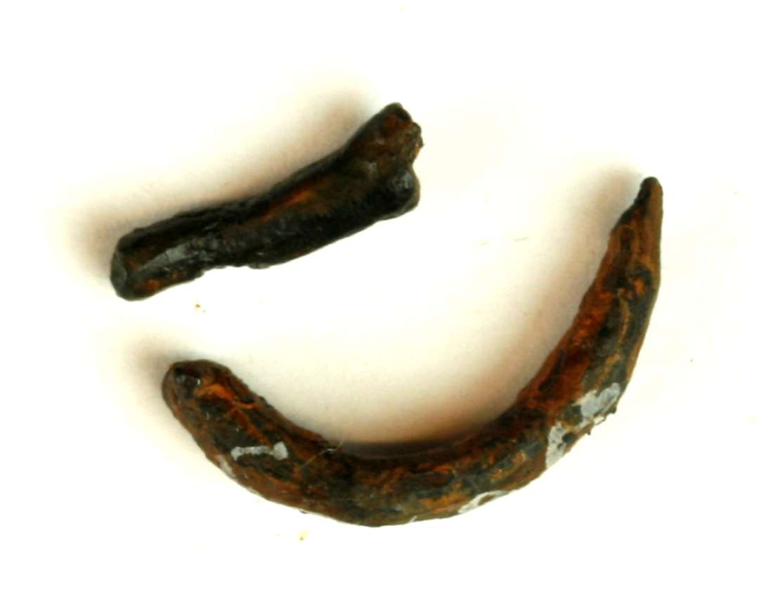 2 fragmenter af jernsøm, det ene med hoved . L : ca. 1,8 cm. Det andet en krumbøjet jernstump. L : 1,85 cm.
