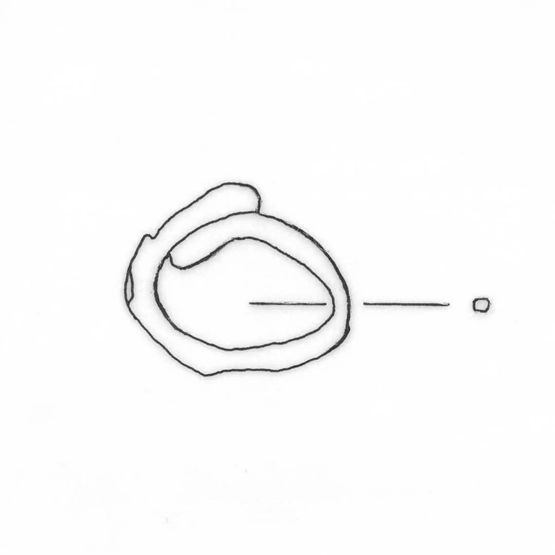 1 forrustet jernring af fortykket oval form med opbrudt sammenføjning. Ringen har uregelmæssig oval tværsnitsform, ca. 0,25 x 0,3 cm. Ydre mål 2,1 x 2,5 cm.