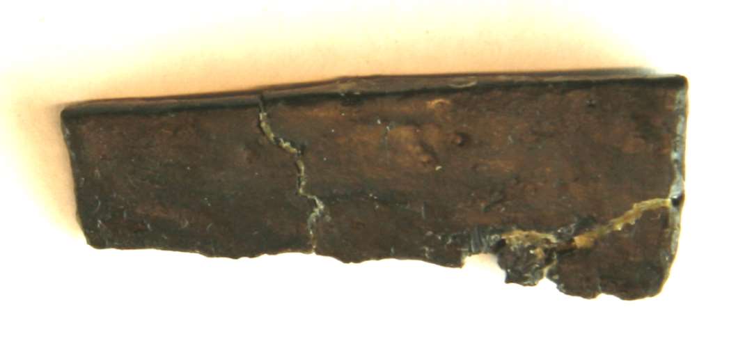 1 stk. brudt, fladt jernstykke. Muligvis fragment af knivblad. Længde: 4 cm.