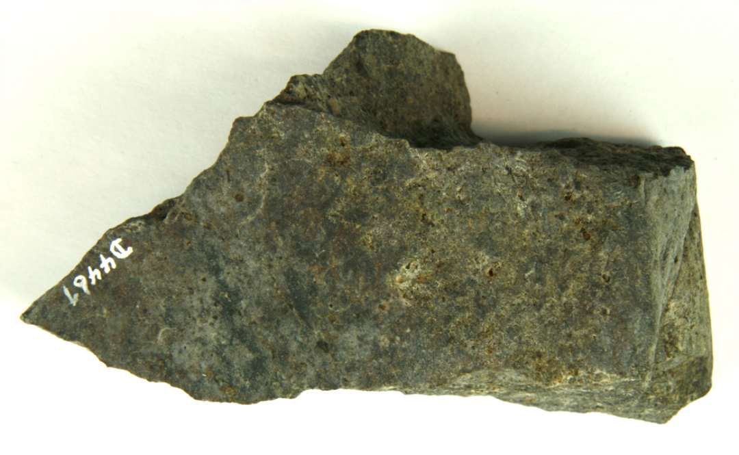 Granit, bearbejdet på to fladsider, med tre uregelmæssige brudflader.