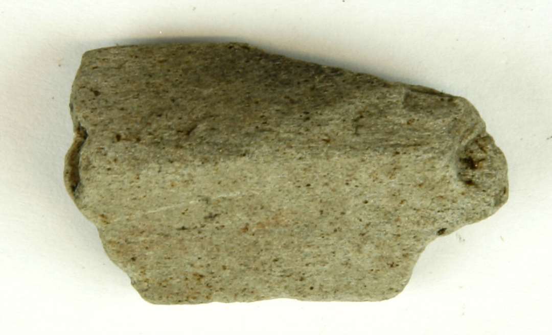 Fragment af stangformet hvæssesten af lysegrå sandsten. Største mål: 4 cm.