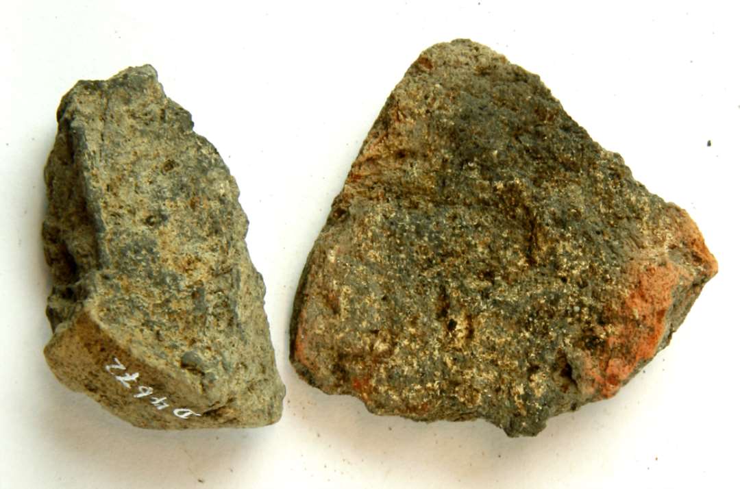 2 fragmenter af discosformede vævevægte af brændt lermasse. Største mål: 4 cm.
