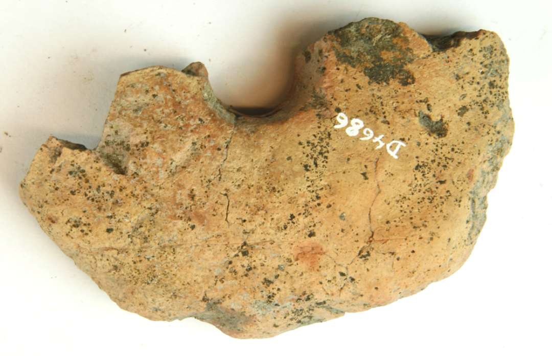 1 fragment af discosformet vævevægt af brungullig lermasse med gråsort kærne. Største mål: 10 cm.