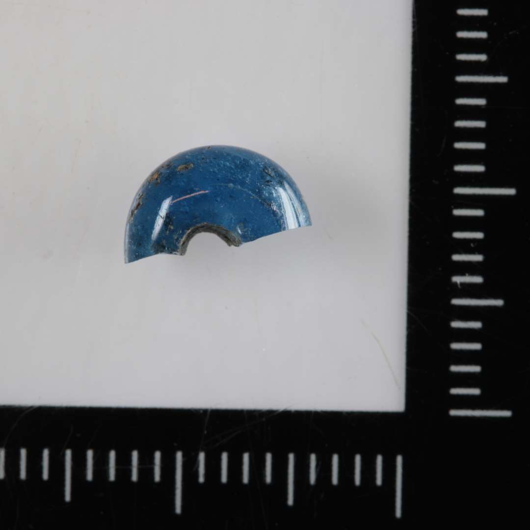 1/2 perle af afrundet ringfom og af gennemsigtigt blåligt glas. 