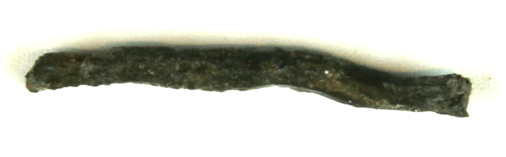 1 let forbøjet, stangformet jernstump afbrudt i begge ender. L : 3,5 cm. Diam : ca. 0,3 cm. 