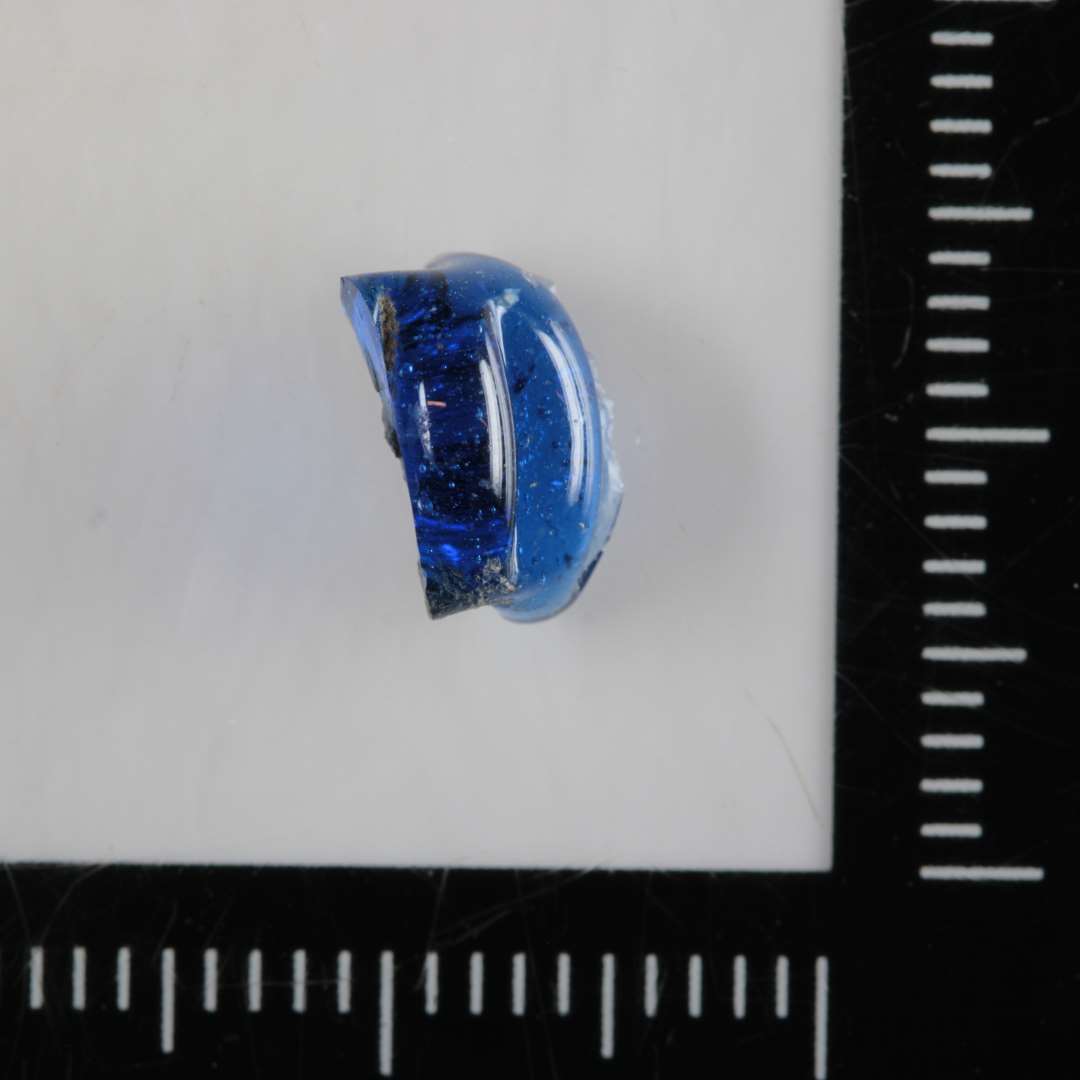 Fragment af melonformet perle gennemsigtigt, blåt glas.