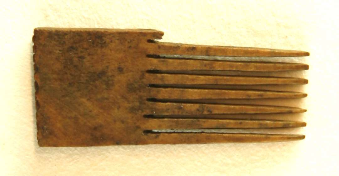 1 fragment af kammellemstykke af hjortetak med en udsavet tandrække i den ene ende. Rygenden er prydet med en meget fin rhombeformet krydsskravering. Største mål: 3,4 cm.