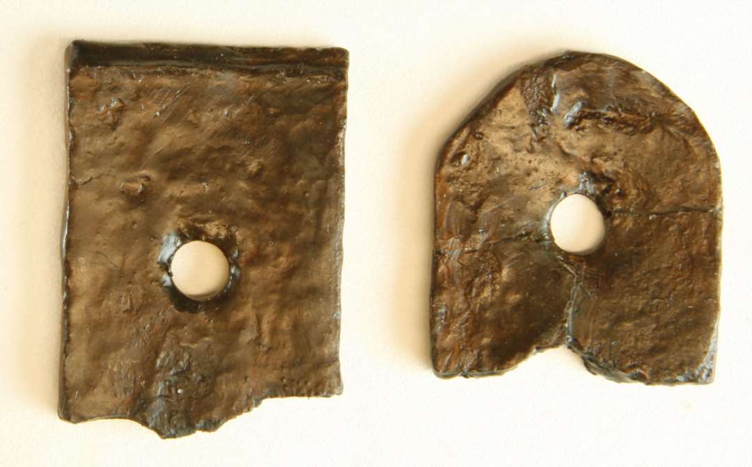 To fragmenter af beslag/hængsler eller lign. af jern. Mål hhv.: 4,5 og 4,5 cm.