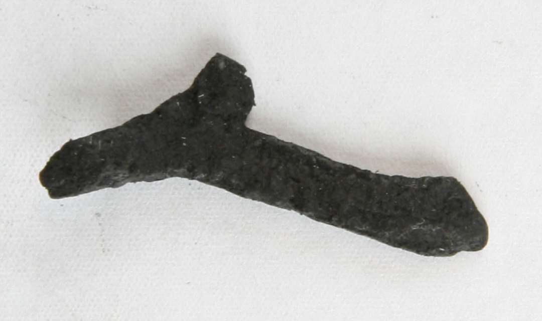 Fragment af spinkel jerngenstand som ser ud til at have en stang som forgrener sig til gaffelform. Længde: 3,5 cm.