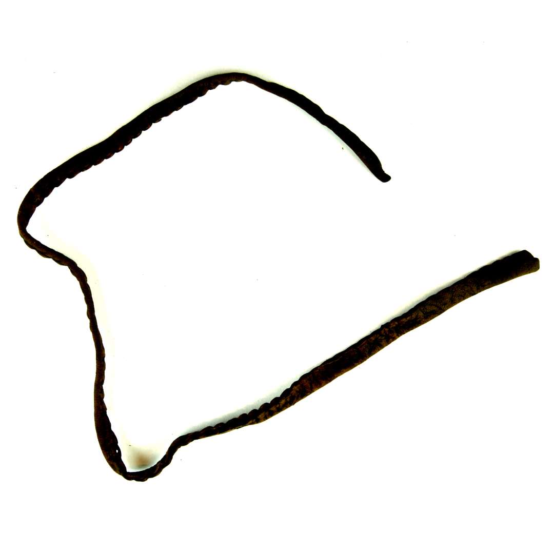 Velbevaret skokantbånd med syhuller langs randene, fremstillet af en ombukket læderstrimmel, der i udfoldet stand måler godt 2 cm. i den ene ende og knap 1,5 cm. i den modsatte ende. Største længde: 62,5 cm.